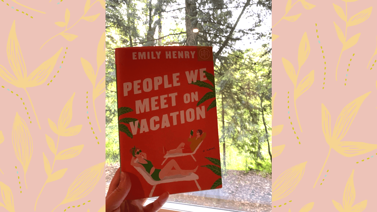 A hand holding the book 'People we meet on vacation' against a window in a forest, on a pale pink background with a yellow leaves pattern.
